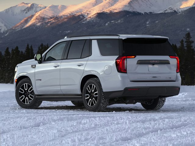 Side view of a white 2024 GMC Yukon parked on snowy ground