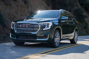 Dark green 2022 GMC Terrain driving on the highway.
