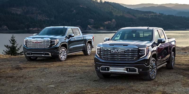 Two 2023 GMC Sierra 1500 pickup trucks parked