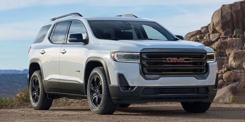 White 2023 GMC Acadia parked on rugged terrain