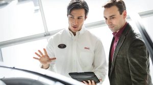 Two men speaking over a car deal.