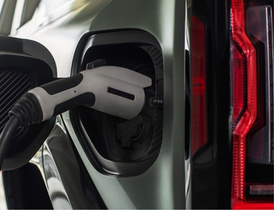 Close up of charging port with charger plugged in on a GMC Hummer EV SUV - Schepel Buick GMC in Merrillville IN